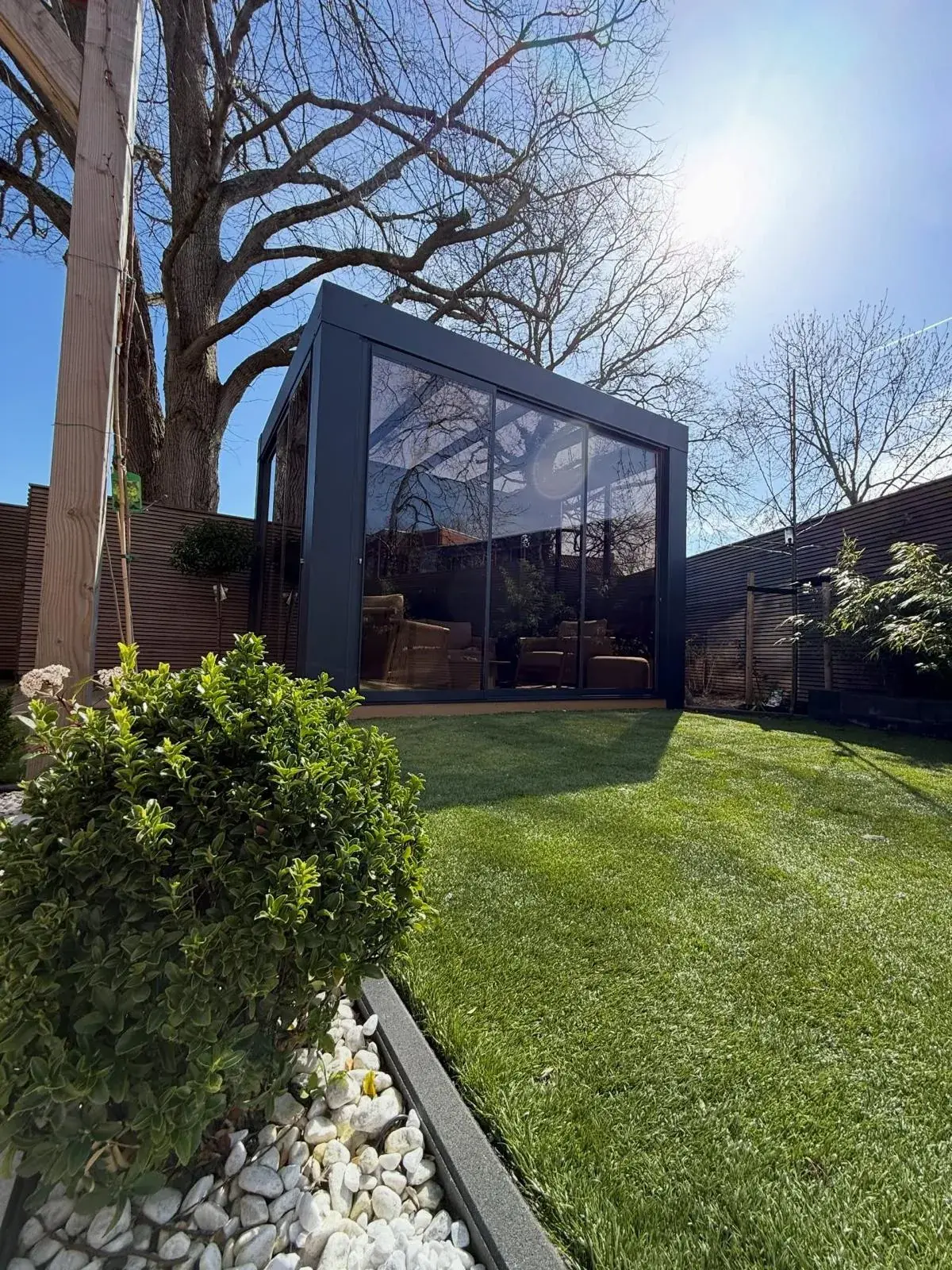 Cube-Veranda mit Flachdach und kräftigen Stützen an einem modernen Haus