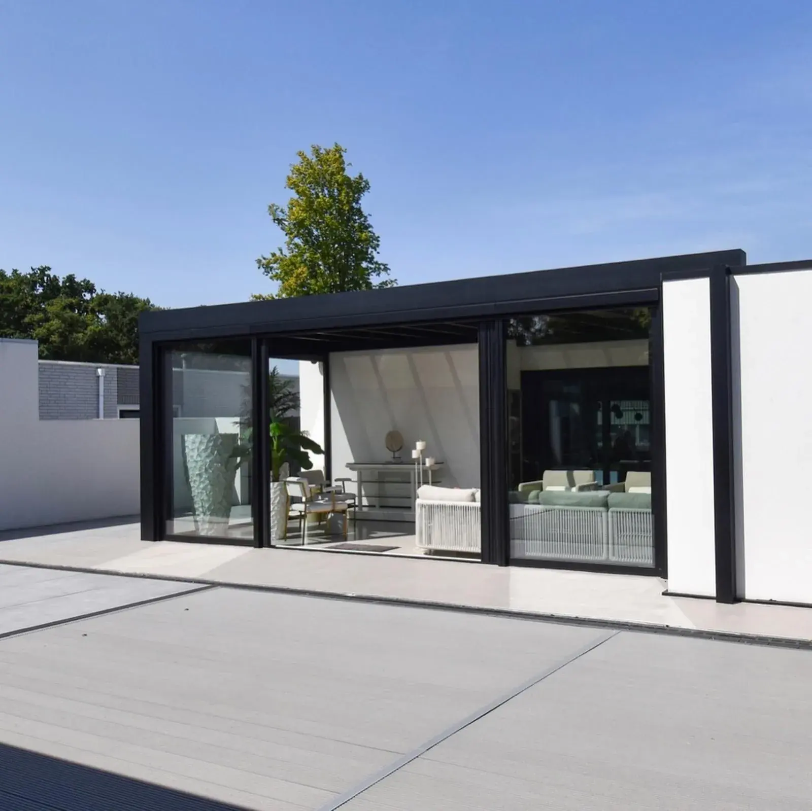 Frei stehende Cube-Veranda mit klarer Verglasung an einer modernen Villa