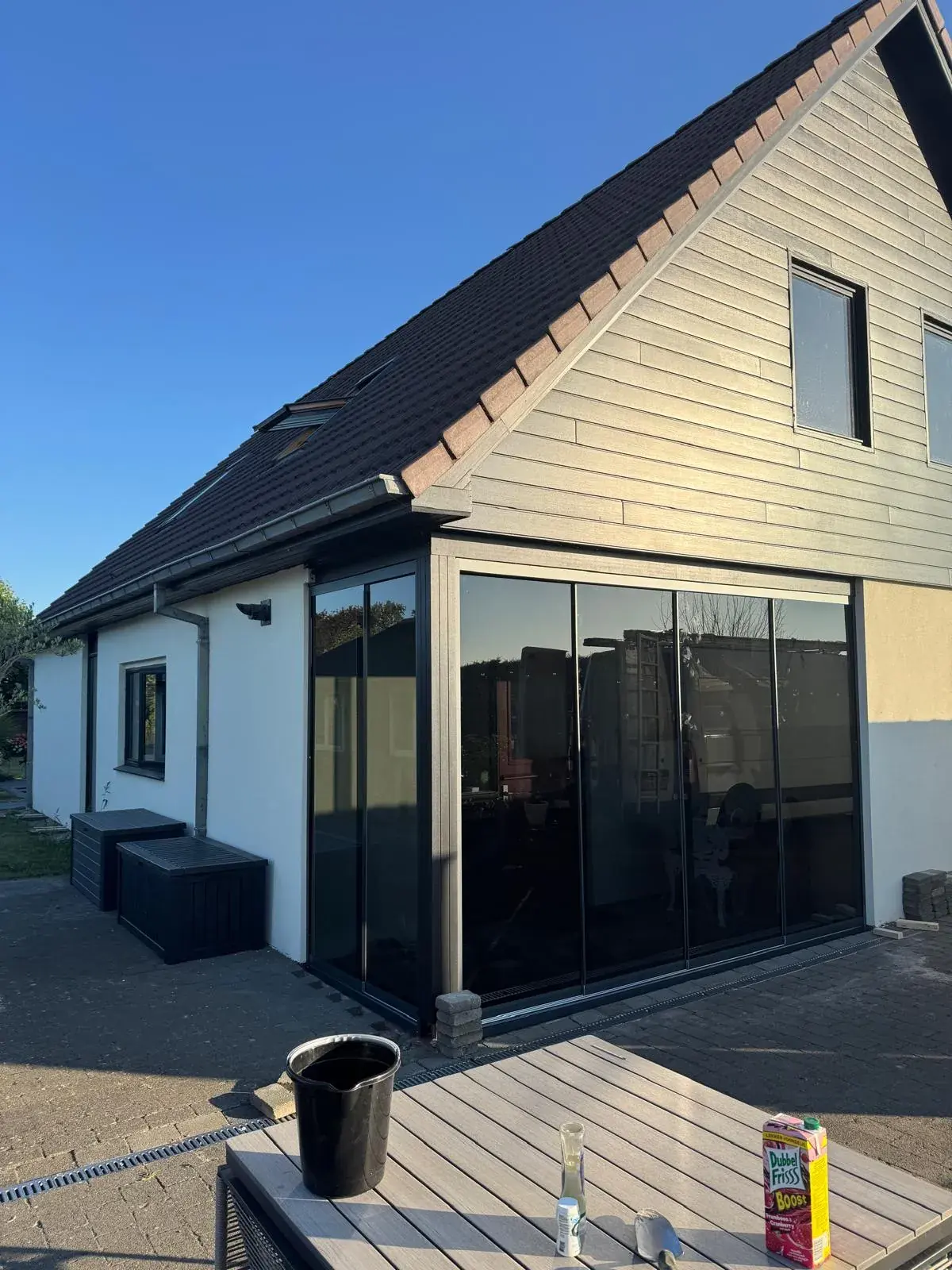 Veranda mit Glasschiebewänden und warmer Beleuchtung am Abend
