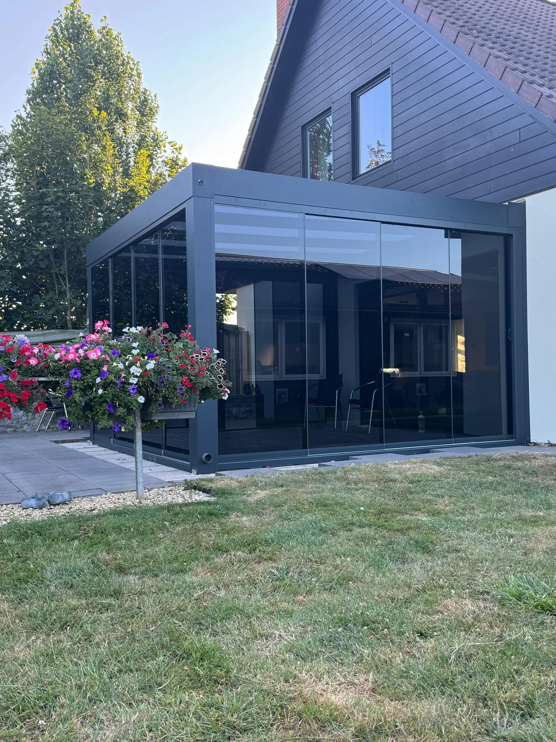Cube-Veranda in Anthrazit vor einer hellen Fassade
