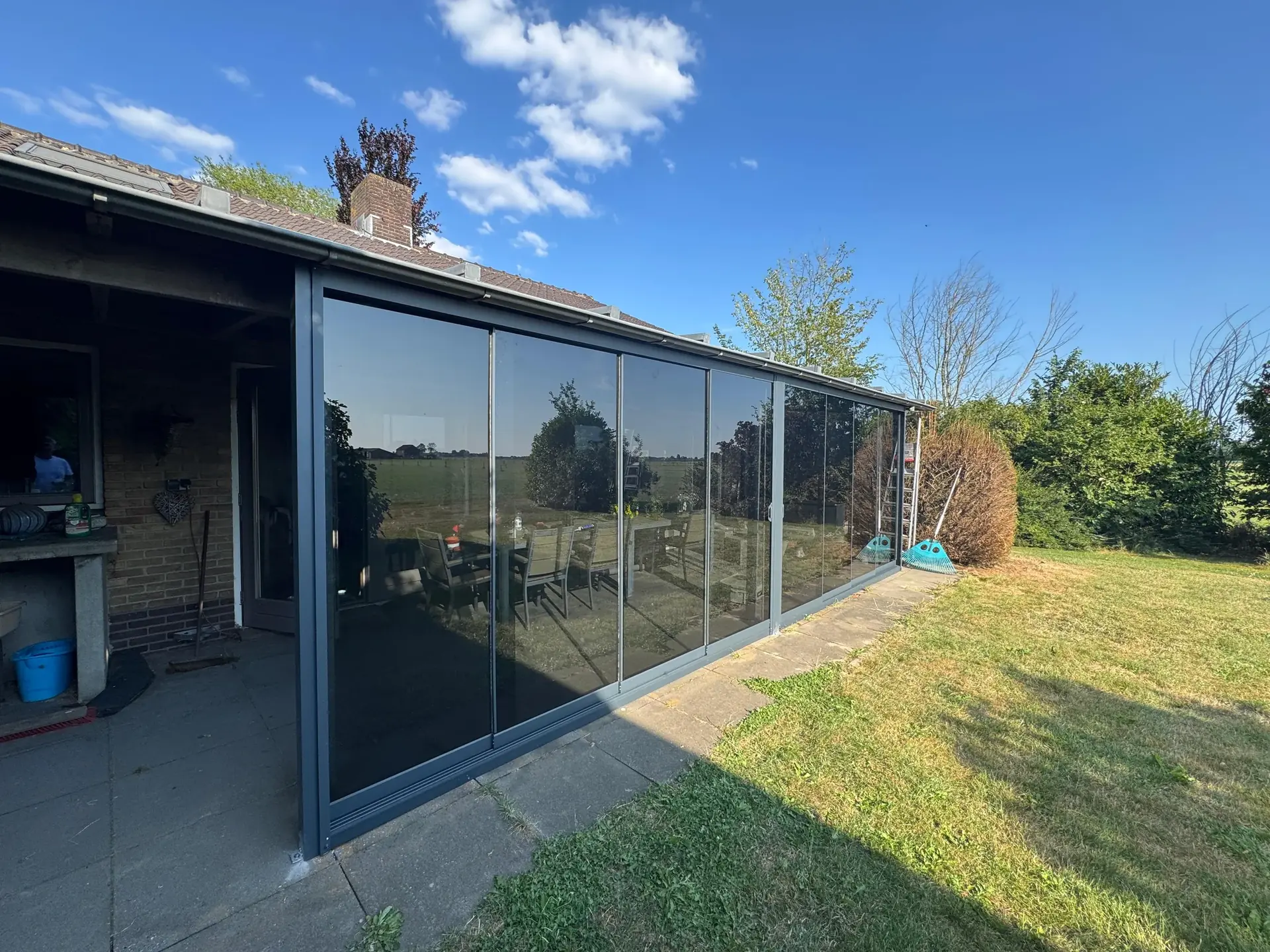 Glasschiebetür mit getönter Verglasung über die gesamte Fassade